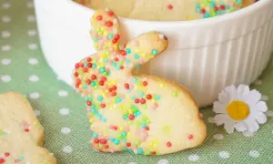 Bunte Osterkekse zum Ausstechen in Hasenform, verziert mit Zuckerstreuseln. Ein süßer Gruß für das Osterfest.