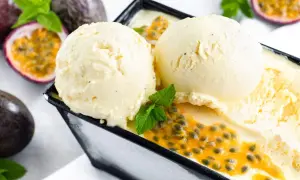 Zwei Kugeln cremiges Maracuja Eis mit frischer Passionsfrucht und Minze. Ein tropischer Genuss!