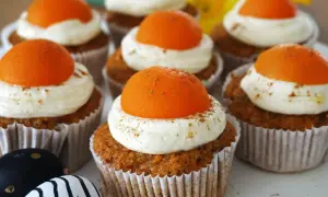 Leckere Oster Muffins mit cremiger Glasur und orangefarbener Deko.