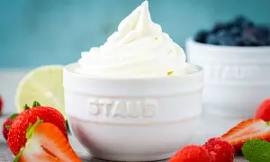 Cremiger Frozen Joghurt, frisch aus der Eismaschine, umgeben von saftigen Erdbeeren und Blaubeeren.