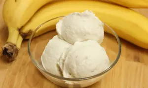 Schon probiert, bananeneis selber machen? Hier ist ein köstliches Ergebnis in einer Schale, daneben reife Bananen.