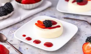 Cremige Panna Cotta, perfekt zubereitet im Thermomix, garniert mit frischen Beeren und Erdbeersauce. Ein Genuss für Augen und Gaumen.