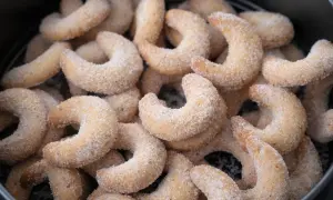 Ein Haufen zarter Vanillekipferl, bestreut mit feinem Zucker, wartet darauf, genossen zu werden.