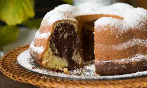 Ein saftiger Gugelhupf Marmor, bestäubt mit Puderzucker, wartet auf seinen Anschnitt.
