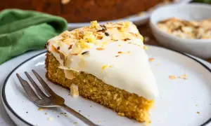 Ein saftiger karottenkuchen mit Frischkäse-Frosting, garniert mit Mandelsplittern und Zitronenschale. Perfekt für jeden Anlass!