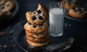 Ein Stapel saftiger American Cookies mit Schokoladenstückchen, daneben ein Glas Milch. Perfekt für das American Cookies Rezept.