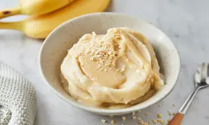 Cremiges italienisches Bananeneis mit Karamellsauce und gehackten Nüssen, garniert mit frischen Bananen.