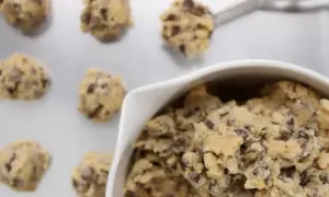 Frisch geformte american cookies mit Schokostückchen auf einem Backblech, bereit zum Backen.