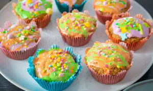 Bunte Karotten Muffins mit Zuckerguss und Streuseln, perfekt für Ostern.