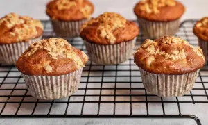 Mehrere goldbraune Haferflocken Muffins mit knuspriger Streusel-Decke auf einem Kuchengitter.