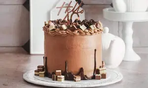 Eine üppige Schoko Torte mit "Hello 40" Topper und Schokoladenstückchen.