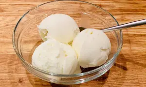 Schüssel mit drei Kugeln Milcheis ohne Sahne, perfekt zum milcheis ohne sahne selber machen. Löffel liegt daneben.