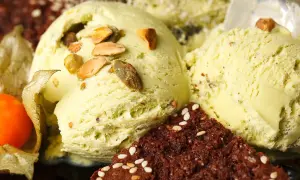 Cremiges veganes Eis selber machen: Pistazieneis mit Nüssen und Schokostückchen, garniert mit Physalis.