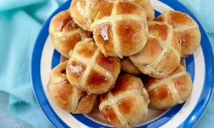 Ein Teller voller goldbrauner Hot Cross Buns, bereit zum Genießen.