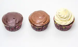 Drei Cupcakes: einer mit dunkler Ganache, einer mit Milchschokoladen-Ganache und einer mit weißer Creme. Perfekt für ein schnelles Ganache Rezept.