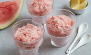 Erfrischendes Wassermelonen-Shave-Ice-Rezept in Gläsern, garniert mit Zitronenspalten und Wassermelone. Perfekt für heiße Tage!