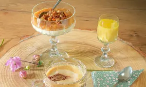 Ein Dessert im Glas mit Rhabarberkompott und Streuseln, daneben ein gelbes Getränk und ein Kaffee.