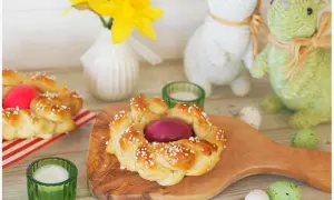 Zwei geflochtene Osterkränze mit gefärbten Eiern, bereit zum Osterfrühstück. Das Backen von Osterkränzen ist eine schöne Tradition.