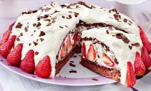 Saftige Stracciatella Torte mit frischen Erdbeeren und Schokostückchen, üppig mit Sahne verziert.