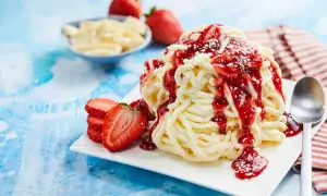 Spaghetti-Eis selber machen mit Kartoffelpresse: Cremiges Vanilleeis mit Erdbeersoße und frischen Erdbeeren. Ein süßer Genuss!
