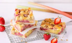 Saftiger Erdbeer Rhabarber Kuchen mit Streuseln, garniert mit frischen Erdbeeren.