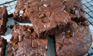 Saftige Zucchini-Brownies mit Schokoladenstückchen, die auf einem Gitterrost liegen.