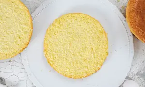 Zwei runde Biskuitböden, einer auf einem Teller, bereit für ein Biskuitteig Rezept Springform.