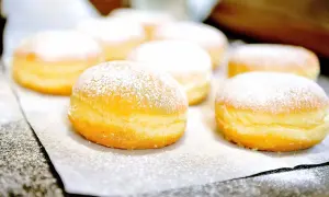 Frisch gebackene Krapfen, mit Puderzucker bestäubt, warten auf das Krapfen Rezept.