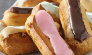 Bunte Éclairs mit Schokoladen-, Erdbeer- und Vanilleglasur. Ein köstliches Éclair-Rezept zum Nachbacken.