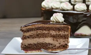 Ein Stück saftige Schoko Sahne Torte mit glänzendem Schokoladenguss und zarter Sahnehaube.