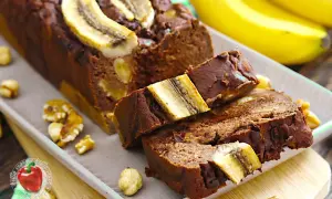 Saftiger gebackener Bananenkuchen mit Nüssen und Bananenscheiben obendrauf. Ein Genuss für jeden Tag.
