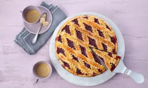 Ein köstliches Linzer Torte Rezept: goldbrauner Teig mit fruchtiger Marmelade, serviert mit Kaffee.
