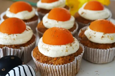 Leckere Oster Muffins mit cremiger Glasur und orangefarbener Deko.