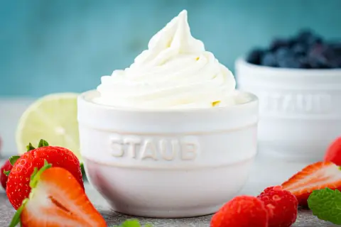 Cremiger Frozen Joghurt, frisch aus der Eismaschine, umgeben von saftigen Erdbeeren und Blaubeeren.