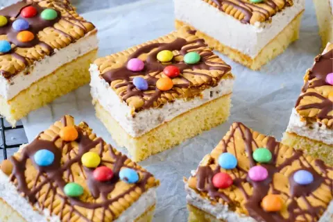 Bunte Geburtstagskuchen für Kinder: saftiger Boden, cremige Füllung, Kekse, Schokoglasur und Smarties.