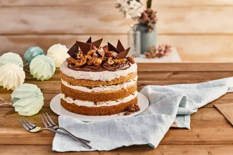 Eine köstliche Nougat Torte mit Schokoladenstücken und Nüssen, dekoriert mit einer Kordel aus Papierlaternen.