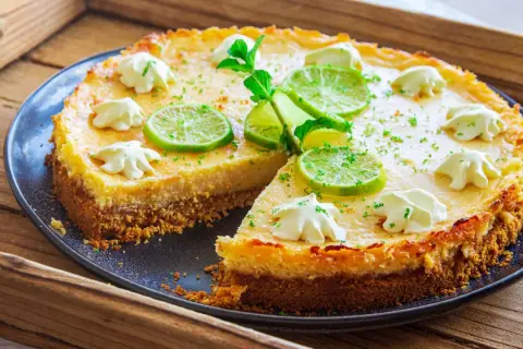 Ein köstlicher Key Lime Pie mit Limettenscheiben und Sahnetupfern, bereit zum Genießen.