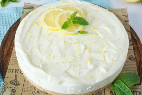 Cremige Mascarpone Torte mit Zitronenscheiben und Minze, bestreut mit Zitronenschale. Ein Genuss für jeden Anlass.