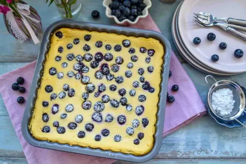 Frisch gebackener Blaubeer-Käsekuchen, bestäubt mit Puderzucker, bereit zum Servieren.