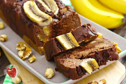 Saftiger gebackener Bananenkuchen mit Nüssen und Bananenscheiben obendrauf. Ein Genuss für jeden Tag.