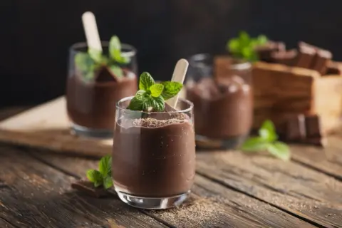 Schokoladenmousse im Glas, garniert mit Minze und Schokostückchen. Perfekt für die Zubereitung mit dem Thermomix.