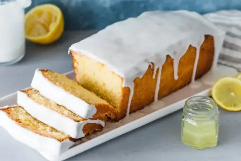 Saftiger Zitronenkuchen mit Zuckerguss, perfekt für Ihr nächstes zitronenkuchen rezept. Frisch geschnitten und mit Zitronenscheiben garniert.