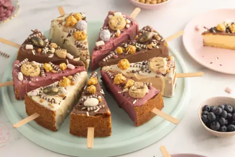 Bunte Cheesecake-Sticks mit Schokolade, Keksen und Popcorn. Ein süßer Genuss für jeden Anlass.