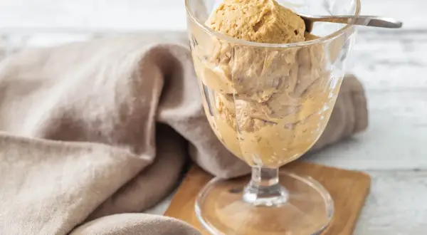 Cremiges Baileys mit Vanilleeis in einem Glas, serviert mit einem Löffel. Ein Leckerbissen für warme Tage.