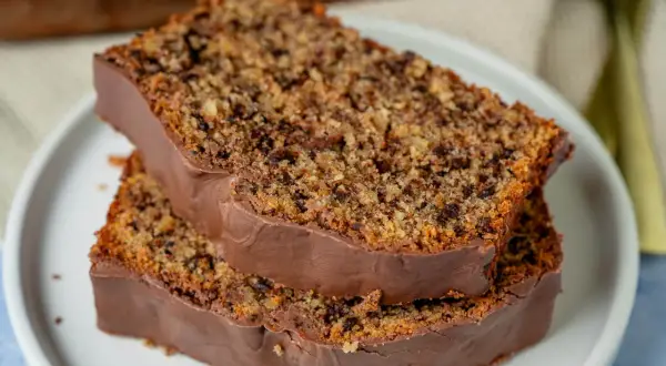 Zwei Scheiben saftiger **Schoko Nuss Kuchen** mit Schokoladenglasur auf einem Teller.