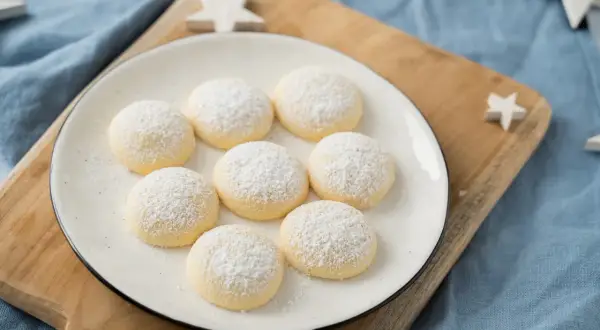 Zarte Butterkekse, bestäubt mit Puderzucker, warten auf das perfekte butterkekse rezept. Dekoriert mit Sternen.