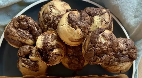 Ein Haufen leckerer Nutella Muffins mit Marmormuster auf einem Teller, bereit zum Genießen.