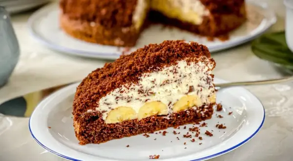 Ein Stück saftiger Maulwurfkuchen mit Bananen und Sahne. Dieses Maulwurfkuchen Rezept ist ein Genuss!