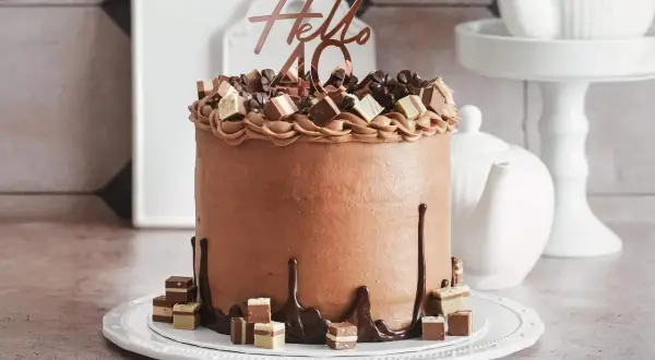 Eine üppige Schoko Torte mit "Hello 40" Topper und Schokoladenstückchen.