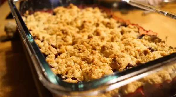 Frisch gebackener Himbeer Crumble in einer Glasform. Die goldbraune Kruste duftet verlockend nach Beeren und Streuseln.